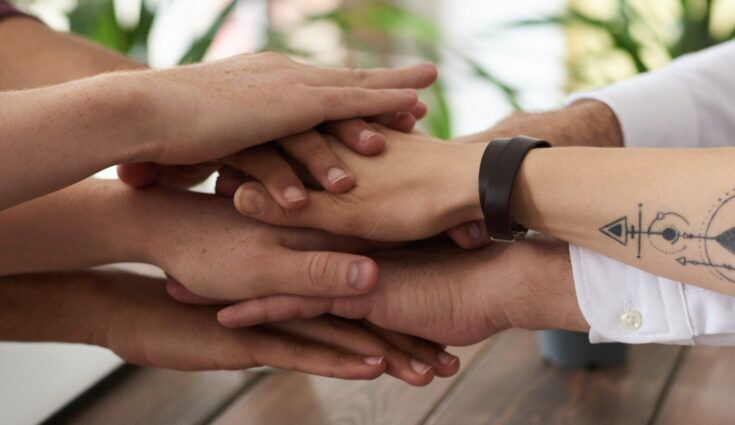 3 sets of hands all stacked on top of each other